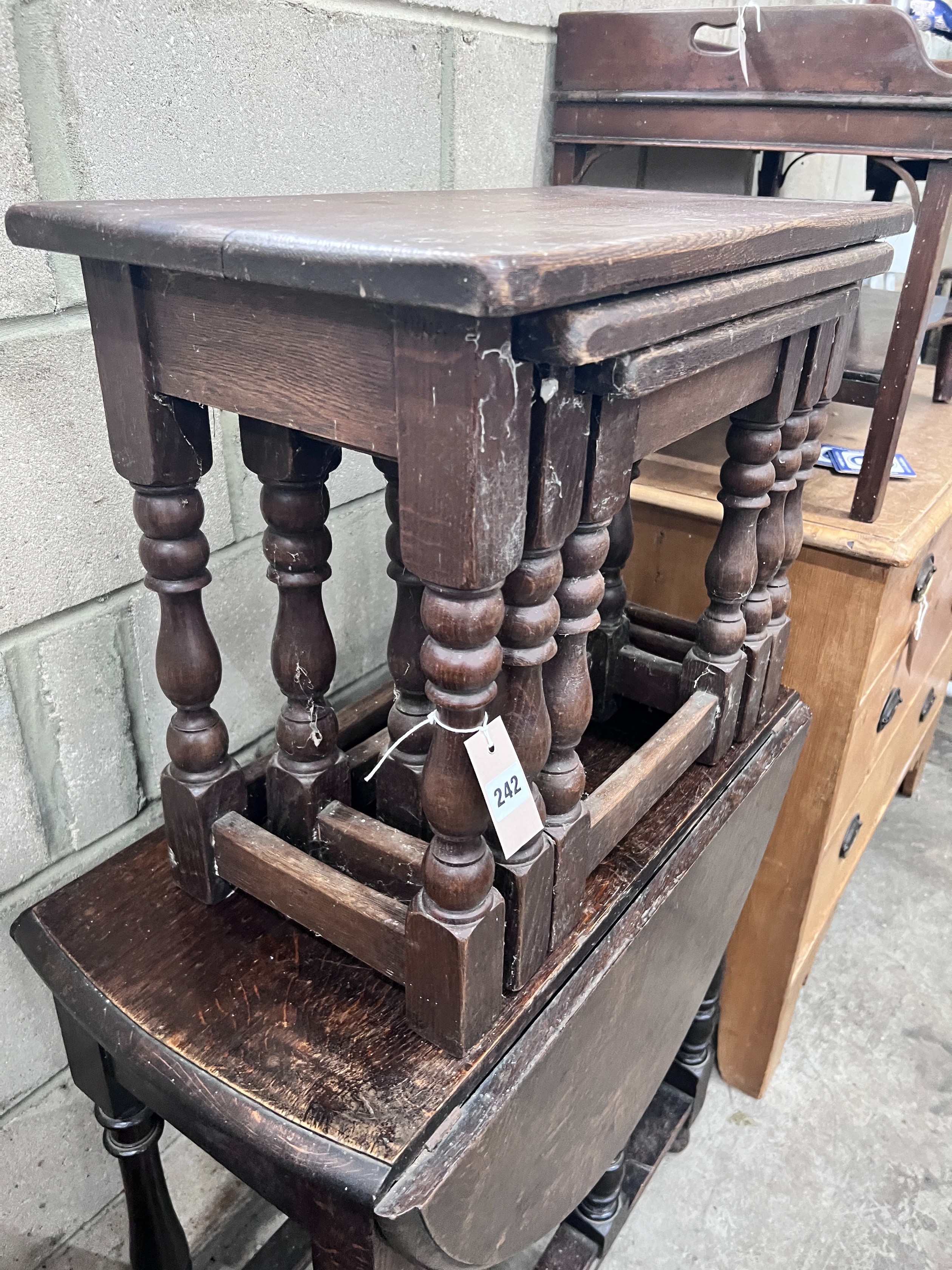An 18th century style oak gateleg table, length 73cm, depth, 103cm, height 77cm, a nest of three oak tables, a mahogany two tier gallery top table and a spinning chair *Please note the sale commences at 9am.